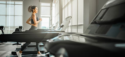 A woman running on a treadmill at the gym
