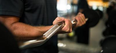 A closeup of a man lifting weights at the gym