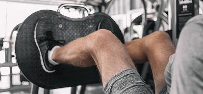 A man on a leg press machine at the gym